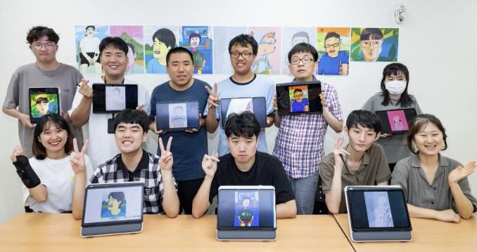 수원시 고향사랑기금 활용 사업으로 진행 중인 호매실장애인종합복지관 디지털 드로잉 작가 양성 교육 참여자 등 관계자들이 작품이 담긴 태블릿을 들고 기념촬영을 하고 있다.
