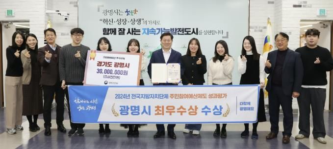 박승원 광명시장(사진 왼쪽에서 일곱 번째)이 '2024년 전국지방자치단체 주민참여예산제도 성과평가' 최우수상 수상을 기념해 예산법무과 직원들과 기념사진을 촬영하고 있다.