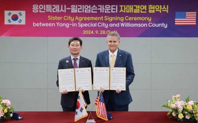 이상일 용인특례시장이 지난해 9월 용인시민의 날 행사 현장에서 빌 그래벨 미국 텍사스주 윌리엄슨 카운티장과 자매결연 협약을 맺고 협약서에 서명했다