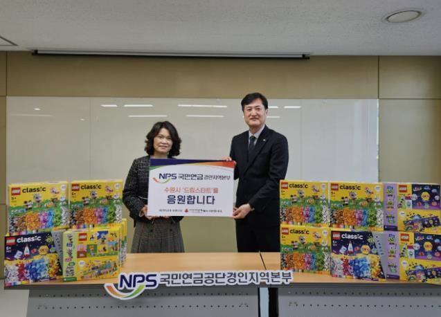 김애영 수원시 아동돌봄과장(왼쪽)과 안홍식 국민연금공단 경인지역본부장이 전달식 후 기념촬영을 하고 있다.